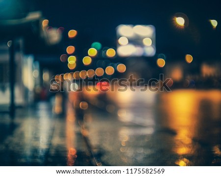view from roadside at blues night after the rain storm with street light street sign and bokeh lights from cars on highway