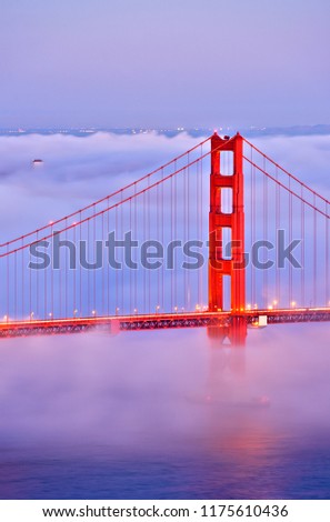 Fog covers the Golden Gate Bridge at sunset, CA-USA