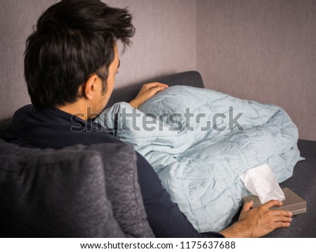 Man on sick bed with tissue paper and blanket