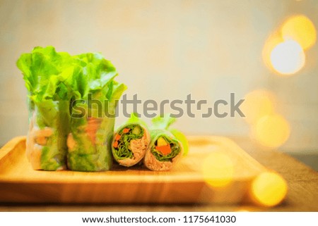 Abstract vintage photography of roll salad with tuna on wooden table, selected focus.