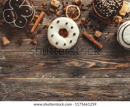 Top view of assorted donuts on wooden background with copy space. Selective focus with effects