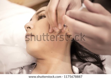 close up danger injection of cosmetic medicine to lifting face with friend.