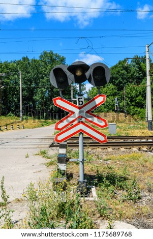 Railroad crossing sign and semaphore in front of railroad crossing