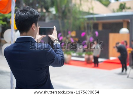 back view of Young Businessman Taking Photos with Mobile.