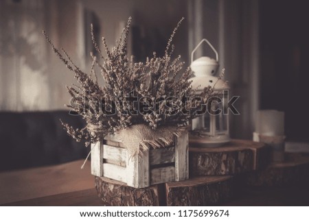 Autumn still life in retro style. Toned image.Pink heather in pot, candles, vintage shutters on background. White lantern. Home interior decoration,Hello autumn, decor details. Vintage