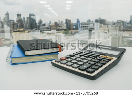 digital calculator with notebook for finance adviser working in office