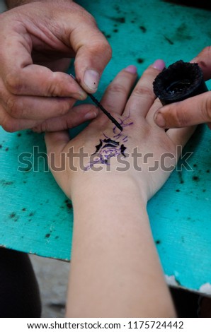 Artist makes tattoo with henna