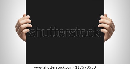 Hands holding black blank paper
