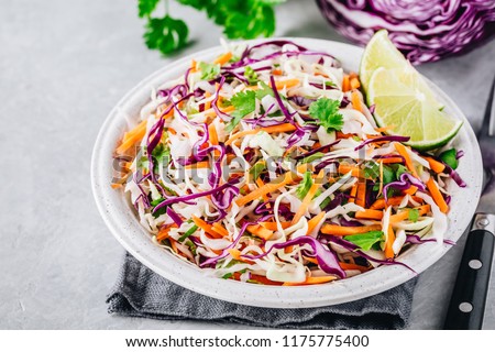 Cilantro lime coleslaw salad with red and white cabbage on gray stone background Royalty-Free Stock Photo #1175775400