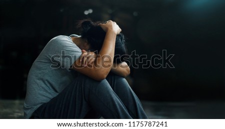 PTSD Mental health concept. Post Traumatic Stress Disorder. The depressed woman sitting alone on the floor in the dark room background. Film look.  Royalty-Free Stock Photo #1175787241