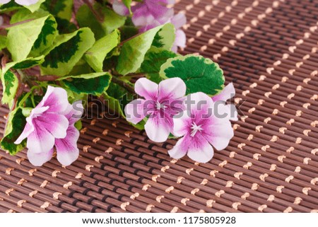 Colorful fabric flowers on bamboo background, closeup picture.