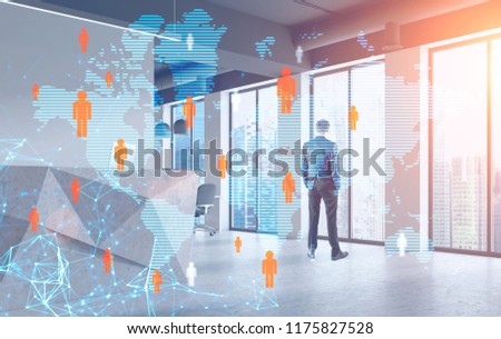 Young businessman looking at city from his office window. Social media and international trade hologram foreground. Toned image double exposure mock up Elements of this image furnished by NASA