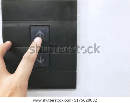 Close up hand push “up” button, elevator (lift) controller.