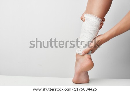 bandaged leg on a gray background                           