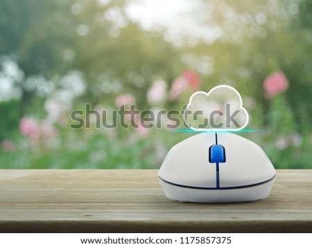 Cloud icon with copy space and wireless computer mouse on wooden table over blur pink flower and tree, Technology cloud computing concept