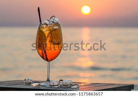 Aperol Spritz Cocktail on sunset. Alcoholic beverage based on table with ice cubes and oranges 