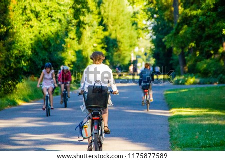 Selective focus on a woman cycling on her bike with many other in the background on a sunny summer day. Driving to work or school with the bike to have a healthy lifestyle Royalty-Free Stock Photo #1175877589