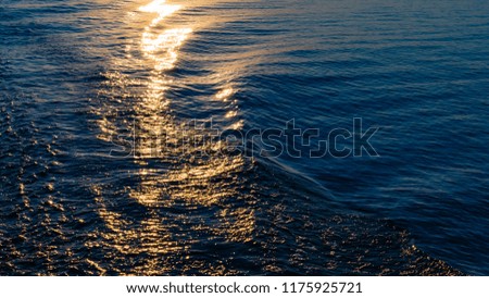 The trail from the boat. Ocean water texture sunrise or sunset.