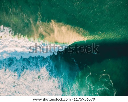 Aerial view of crashing wave in ocean with warm sunset light. Wave crashing on reef. Top view