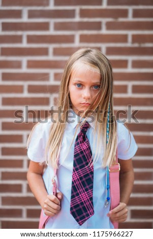 Beautiful cute schoolgirl posing in a street