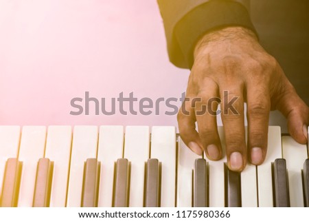 Closeup of playing the piano music instrument under sun flare light.