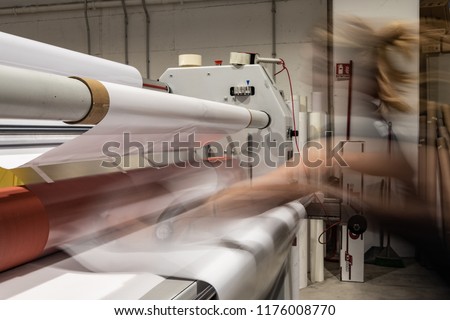 Big printing machine and laminator, armed with red rolls and transparent film. Royalty-Free Stock Photo #1176008770