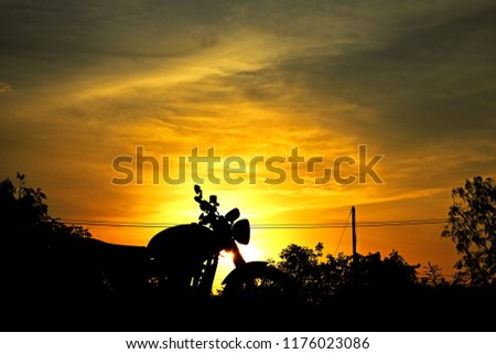 silhouette photography of classic motorcycle standing at the forest while sunset.