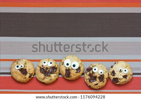 Halloween cookies border on striped orange brown background