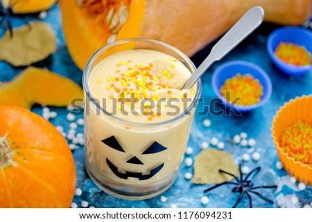 Pumpkin whipped cream dessert in a halloween glass