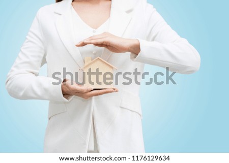 Close up of hand holding model house, Home Buying Ideas Auction Residential Property Service offered by the agent. The monthly installment. isolated  on blue background and clipping path