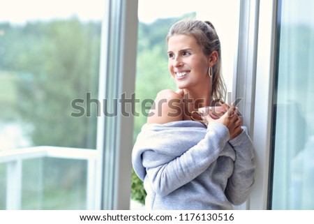 Picture of adult woman wearing warm sweater resting at home one autumn day