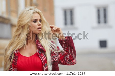 Photo of fashionable girl with beautiful blond hair in autumn city