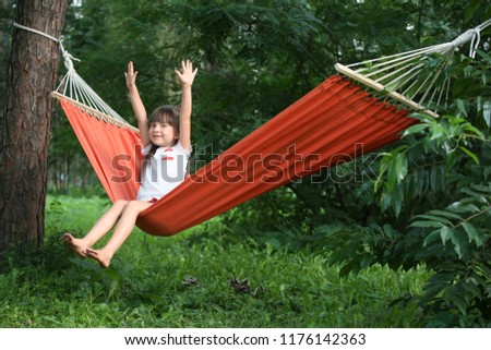 Cute little girl relaxing in hammock on summer day