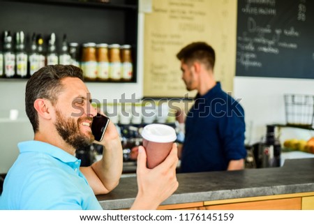Confident entrepreneur choose drink in paper cup to go while communicate mobile. Man speak mobile phone and drink coffee cafe bar background. Man solving problems phone have coffee. Happy to hear you.