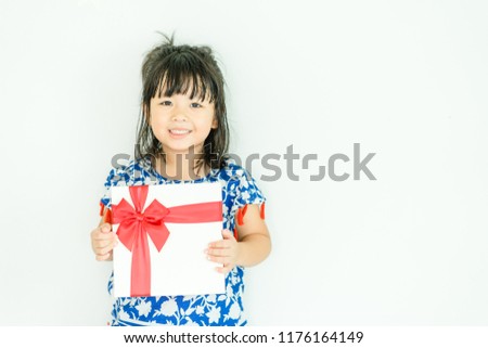 Little asian girl smile and holding red gift box on white background.child holding gift box.