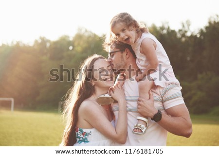 Happy family, father of mother and daughter of baby in the nature at sunset.