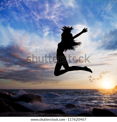 sunset on background beach with sea waves and long haired girl jumping