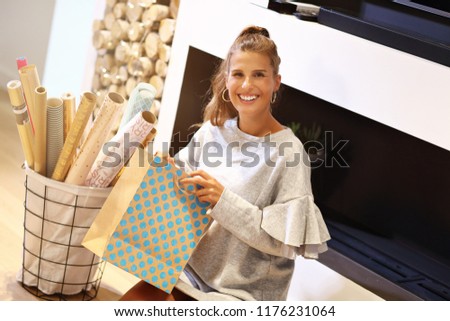 Adult woman at home wrapping Christmas presents