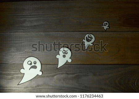 Halloween.  Symbolic figures of spiders, ghosts and bats carved from paper. Holiday elements on wooden background.