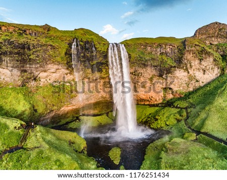 Iceland waterfall nature travel landscape in Icelandic nature background. Popular tourist attraction summer holiday destination in on South Iceland. Aerial drone view of top water falls.