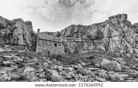 St Govan's Chapel, an ancient Welsh religious site built into a cleft in the cliffs, in Pembrokshire, south-west Wales, UK. A high contrast monochrome edit. 