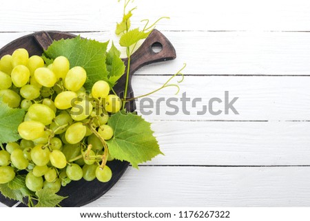 Grape. Fresh white grapes on a white wooden background. Top view. Free space for text.