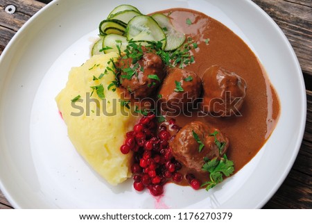 Köttbullar - Traditional Swedish meatballs with cream sauce, mashed potatoes, pickled cucumber, and lingonberry jam Royalty-Free Stock Photo #1176270379