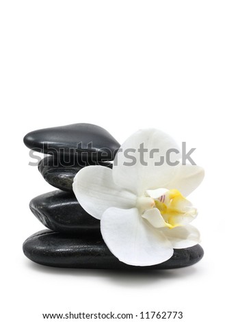 Pyramid of four stones and white orchid on white background