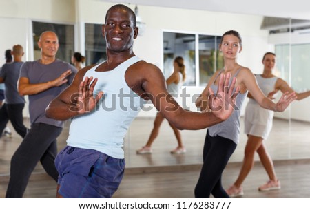 Group of multinational happy people dancing together in modern studio