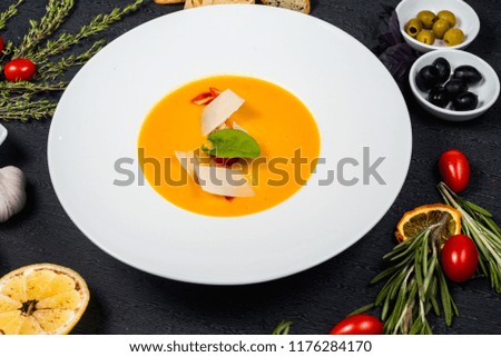 Pumpkin cream soup with slices of tender cheese
