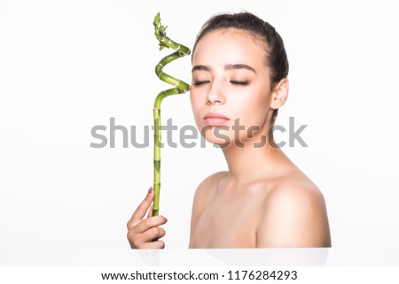 Young woman with green leaf, isolated on white. Beauty natural make up. Spa and wellness and skin care concept. Close up, selective focus, copy space.