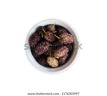 Mulberries in a wooden bowl with copy space for text. Ripe and tasty mulberry isolated on white background. Top view.