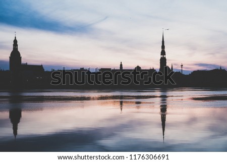 Reflection of city on water, small city of europe, Riga, Latvia in early morning time. City silhouette  
