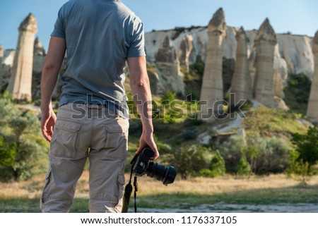 Photographer holding DSLR camera in mountains in Turkey